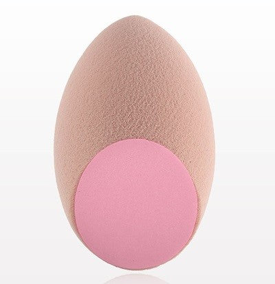 A beige and pink dual textured blending sponge for makeup application.