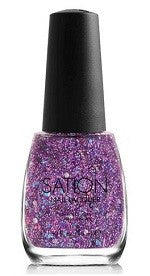 A bottle of Sation nail polish with a glittery purple color, Prettiest Player 9028, in a clear base with larger silver holographic hex glitter and scattered pink and blue hex glitter.
