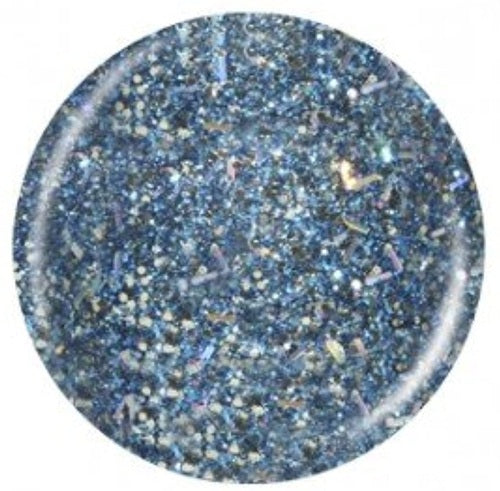 Round nail polish swatch of blue glitter on a white background