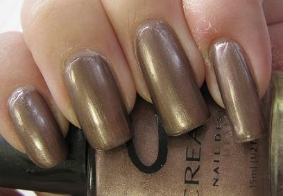Close-up of painted fingernails with brown shimmer nail polish holding a bottle of Creative Nail Design nail polish bottle.