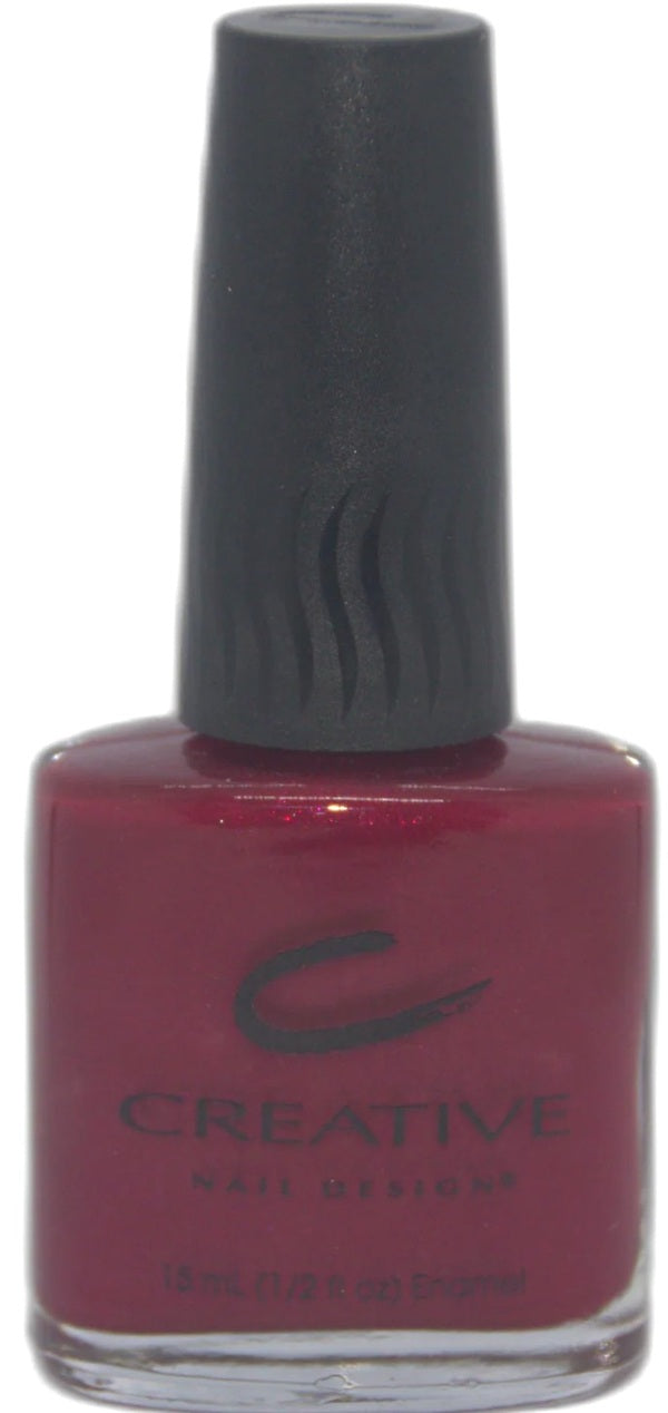 Bottle of Creative Nail Designs nail polish with a dark red color and black cap.