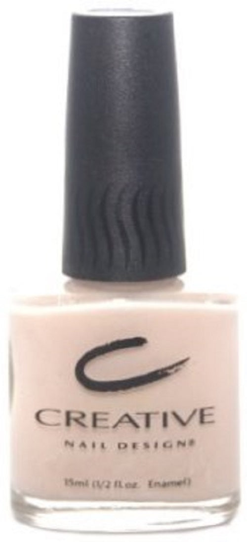 A bottle of Creative Nail Design nail polish in a pale pink color, with the product branding visible on the bottle.