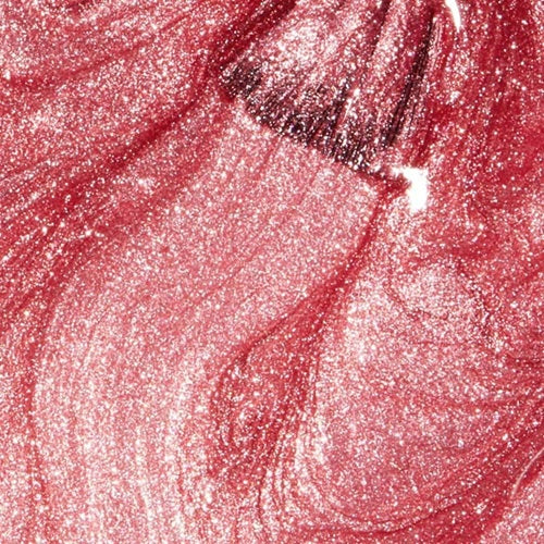 Close-up of peach shimmer nail swatch with a brush.