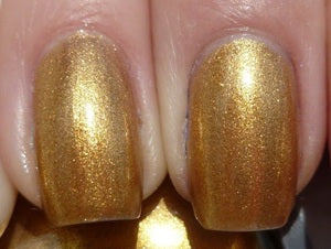 Close-up of nails with gold nail polish on a neutral background