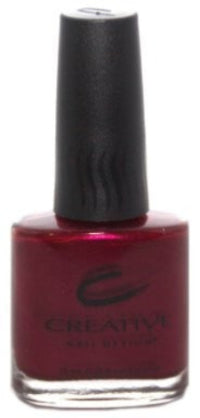 A bottle of Creative Nail Design nail polish in a red color, with the cap on and the brand logo visible on the bottle.