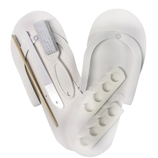 A pedicure kit including white pedi slippers, toe separators, a manicure brush, a plastic file, and a birchwood stick, all arranged in a heart-shaped holder.