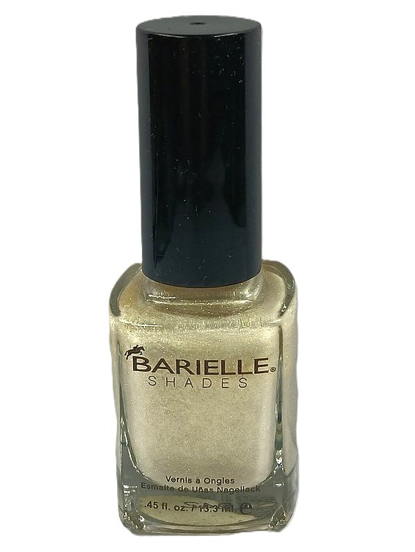 A bottle of Barielle nail polish in color Uninhibited 5028, displaying a very light gold nail polish with golden shimmer.