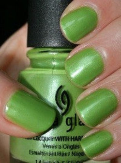 Apple green nail polish on nails holding a China Glaze bottle.