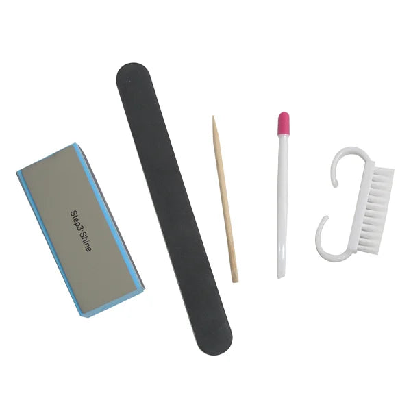 Set of nail care tools including a file, black stick, toothpick, pink and white tool, and white brush on a white background.