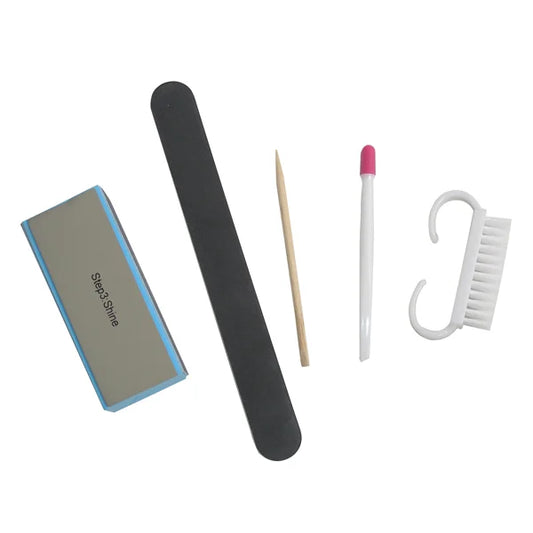 Set of nail care tools including a file, black stick, toothpick, pink and white tool, and white brush on a white background.