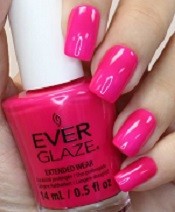 Bright fuchsia nail swatch on nails with nail polish bottle.
