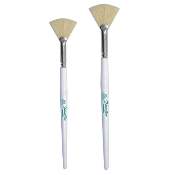 Two fan facial brushes with white handles and bristle heads on a white background