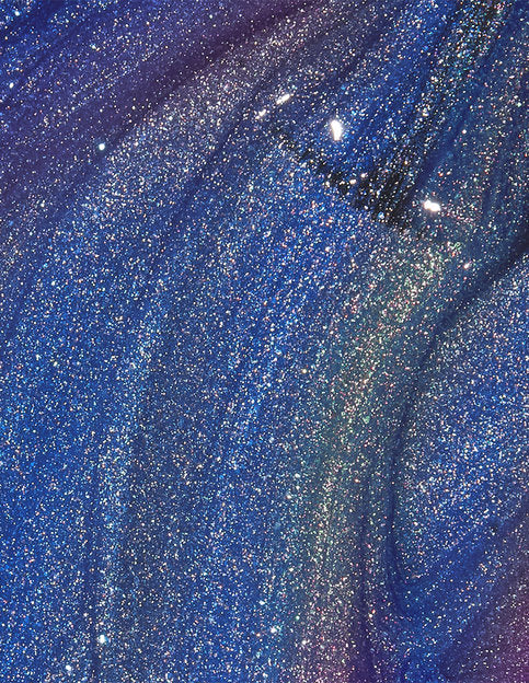 Close-up of blue nail polish with glittery texture
