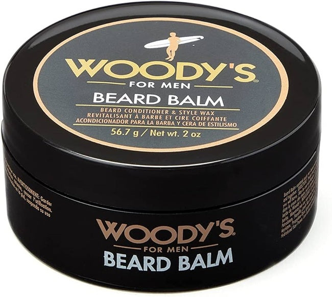 A black round tin of Woody's For Men Beard Balm, featuring a black lid with a gold and white circular label and a black body with gold and white text.