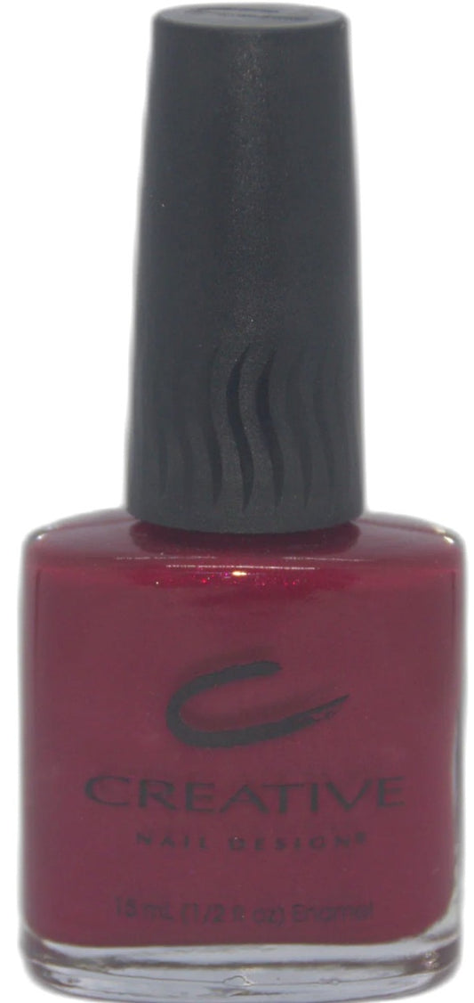 Bottle of Creative Nail Designs nail polish with a dark red color and black cap.