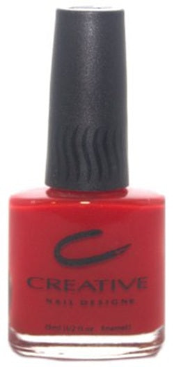 A bottle of Creative Nail Design nail polish in bright tomato red color with orange undertones.