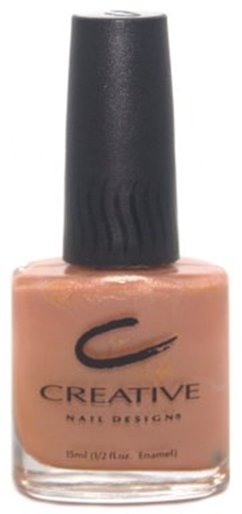 A bottle of Creative Nail Design nail polish in a semi-sheer peach color with iridescent pink shimmer.