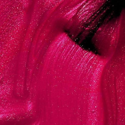 Close-up of a pink shimmer nail polish swatch with a black brush
