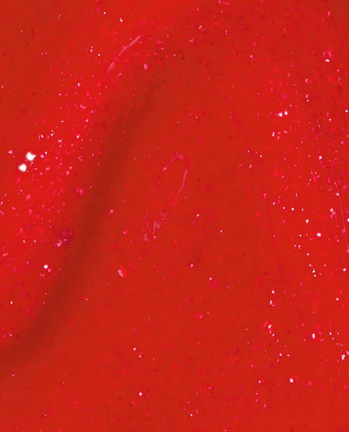 Close-up of a red shimmer nail polish swatch.