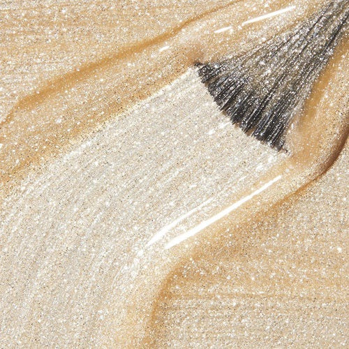 Close-up of a light gold shimmer nail polish swatch with brush.